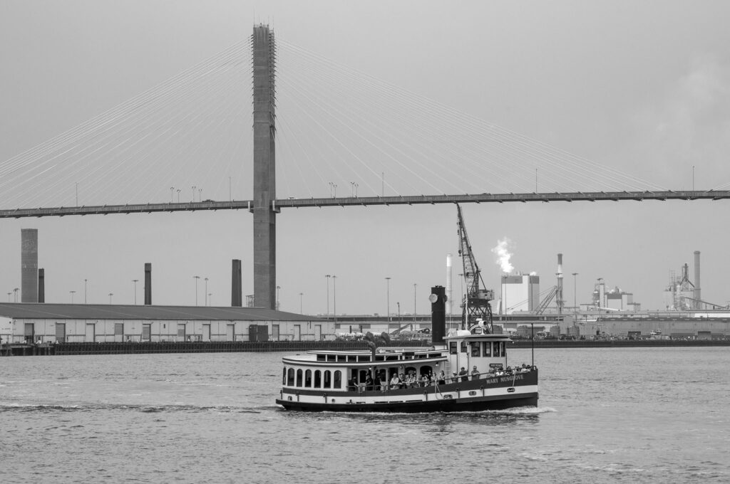 Container ship and tugboat moving beneath the Talmadge Memorial Bridge in Savannah, Georgia.